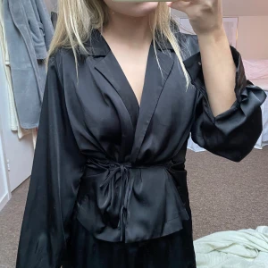 Svart omlottklänning - Svart omlottblus med knytband i midjan😍