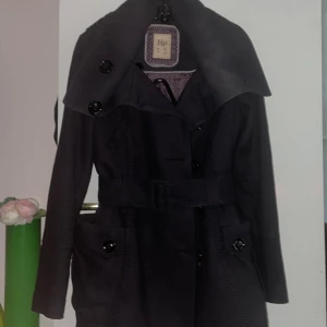 Svart jacka  från Pull and bear  - Snygg svart jacka från Pull and bear  med stora knappar och bälte i midjan. Perfekt för höst och vår. Den har långa ärmar och en stilren design som passar till många tillfällen.