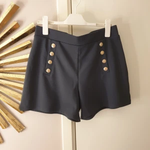 shorts  - mörkgråa shorts med guldknappar från H&M. Helt oanvända