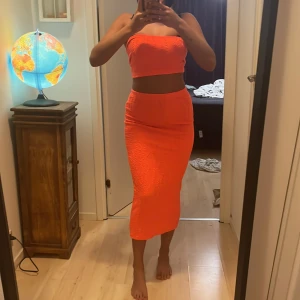 skrik orange snyggt set  - Snygg SET   i en tight passform.  är knälång och har en ribbad textur som ger en trendig look. Perfekt för att sticka ut med en färgstark stil.