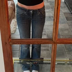 Lågmidjade utsvängda jeans - Jätte fina vintage jeans från guess. Fint skick förutom att de är lite slitna längst ner. Sitter som en xs😊 kom privat för frågor eller mått!