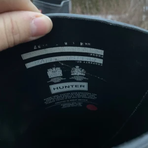 Svarta stövlar från Hunter - Säljer ett par klassiska svarta stövlar från Hunter. De är höga med en justerbar rem på sidan och har en robust design som passar perfekt för regniga dagar.