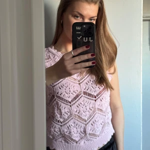 Rosa stickad ärmlös topp - Säljer denna söta stickade topp/väst. Snyggt stickat mönster och har ribbade kanter. Perfekt för lager-på-lager eller sommarens varma dagar. Är i den perfekta rosa färgen och i fint skick