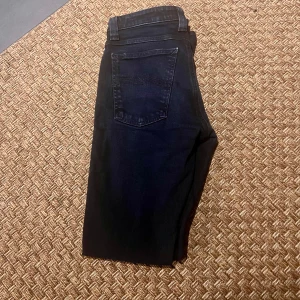 Svarta jeans från Nudie Jeans - Snygga svarta jeans från Nudie Jeans med klassisk femficksdesign och knappgylf. Perfekta för en stilren look.