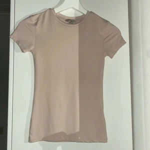 Beige kortärmad t-shirt - Säljer en enkel och stilren beige t-shirt med korta ärmar. Perfekt basplagg för alla tillfällen. Passar bra till jeans eller kjol.