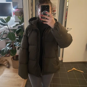 pufferjacka - Pufferjacket i khaki färg, har en liten fläck på ärmen