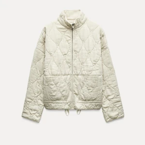 Beige/naturfärg quiltad jacka - Beige/naturfärg quiltad jacka från Zara. Använd en del gånger. Finns vissa defekter, som att ena fickan är sönder inuti. För övrigt fin jacka. 