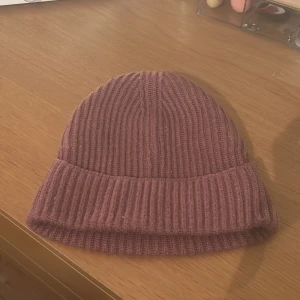 Ribbad rosa mössa - Snygg och enkel ribbad mössa i en mjuk rosa nyans. 