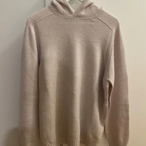 Beige hoodie från Gran Sasso storlek L - Säljer en stilren beige hoodie från Gran Sasso, tillverkad i Italien. Tröjan har en klassisk design med långa ärmar och en bekväm huva. Perfekt för en avslappnad och elegant look. Den är helt ny, aldrig använd. Köpt på Care of Carl. Storlek L, 52.