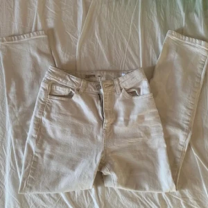 Beige jeansbyxor - Snygga beige jeansbyxor med klassisk femficksdesign och knappgylf i stl 152. Perfekta för en avslappnad stil. De har en rak passform och är tillverkade i ett slitstarkt material.