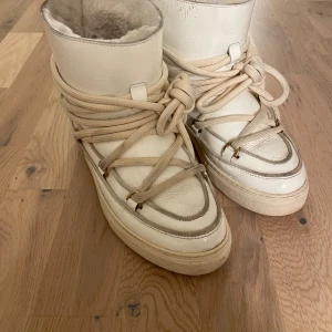 Vita boots från Inuikii - Säljer ett par vita Inuikii boots med snörning och mjukt foder. Perfekta för kalla dagar med sin robusta sula och stilrena design. De har en högre skaft och är gjorda i skinn. Säljer eftersom dem är för små 