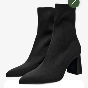 Svarta boots med klack - Eleganta svarta boots med spetsig tå och hög klack. Tillverkade i ett stretchigt material för en tight passform. OANVÄNDA!!