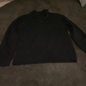 Svart tröja med dragkedja från LMTD - Säljer en stilren mörkblå tröja från LMTD med dragkedja vid halsen. Perfekt för kyligare dagar med sin långärmade design och ribbade detaljer vid ärmslut och nederkant.