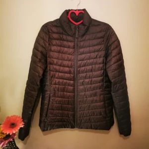 Grå tunn pufferjacka - Snygg grå pufferjacka med dragkedja framtill. Jackan har en stilren design med långa ärmar. Jackan är tunn. 
