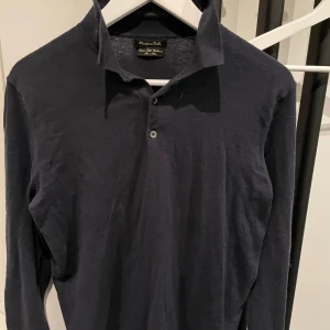 Svart långärmad pikétröja från Massimo Dutti - Elegant svart långärmad pikétröja från Massimo Dutti. Perfekt för en stilren look med en klassisk krage och knappdetalj framtill. Size S.