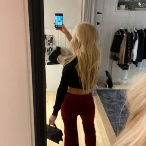 Vintage röda sammetbyxor - Snygga röda vintage hm byxor med låg midja och vida ben. Perfekta för att ge en färgklick till din outfit. Byxorna har även en snygg söm på benen😊