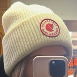 Vit ribbad mössa från Fjällräven - Intressekoll!!! Snygg vit ribbad mössa från Fjällräven med det klassiska märket framtill. Perfekt för kyliga dagar och en stilren accessoar till din vintergarderob. Använd 1 gång!  