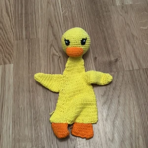 Gul virkad anka - Charmig gul virkad anka med orange näbb och fötter. Perfekt som en söt dekoration eller leksak. Den har detaljerade ögon och är handgjord med kärlek.