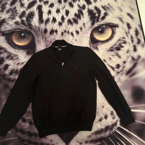 Svart tröja från BOSS - Säljer en stilren svart tröja från BOSS i storlek L men skulle säga den passar M. Tröjan har en dragkedja vid halsen och är perfekt för både vardag och fest. Den är tillverkad av finaste italienska garnet vilket ger en lyxig känsla. Passar perfekt till höst och vinter!