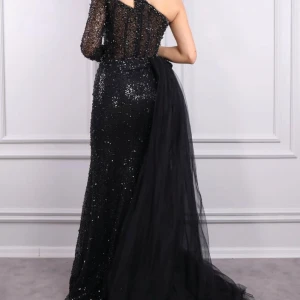 Svart glittrig långklänning - Säljer en fantastisk svart glittrig långklänning med en unik oneshoulder-design. Klänningen har en elegant slits och en dramatisk öppen rygg. Perfekt för bröllopsfesten eller en glamorös bal. Den är i mycket bra skick och redo att glänsa på nästa event! ✨