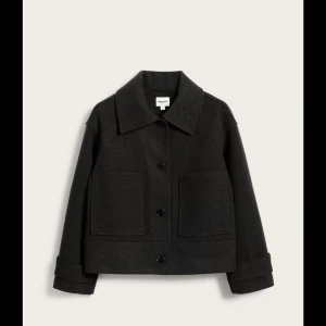 Svart kavaj från Kappahl  - Snygg svart kavaj från Kappahl med stora fickor framtill och knappar. Den har en klassisk krage och är perfekt för en stilren look. Passar bra till både vardag och mer uppklädda tillfällen.