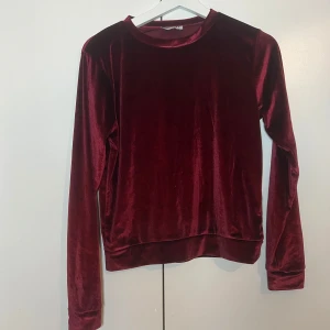 Vinröd sammetset Madlady - Säljer en snygg vinröd sammetsstet från Madlady. Setet har en klassisk rund hals och långa ärmar, perfekt för en stilren look. Materialet är mjukt och lyxigt, vilket gör den både bekväm och trendig.