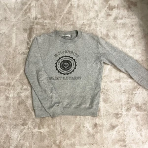 Saint Laurent tröja  - Säljer en snygg grå sweatshirt från Saint Laurent.  Den är i storlek XS men passar defenetift större S eller M, Om det är några funderingar är det bara att höra av sig 