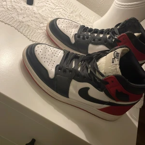 Nike Air Jordans i svart, vitt och rött - Säljer ett par snygga Nike Air Jordans i klassiska färgerna svart, vitt och rött. Skorna har en cool design med snörning och är i mycket bra skick. Perfekta för både vardag och fest! 🏀