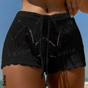 Svarta stickade shorts från SHEIN - Snygga svarta stickade shorts från SHEIN, perfekta för sommaren. De har en loose passform och är dekorerade med ett fint spetsmönster. Midjan är elastisk med en knytning framtill för extra komfort. Perfekta för en dag på stranden eller en avslappnad sommarkväll.