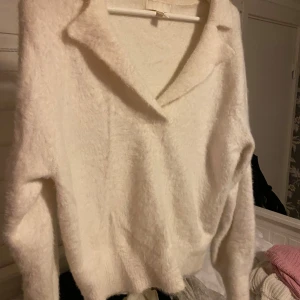 Vit fluffig tröja - Mysig vit tröja i fluffigt material, perfekt för kyliga dagar. Den har en avslappnad passform med långa ärmar och en stilren krage. Perfekt för både vardag och mysiga hemmakvällar. 🧥✨
