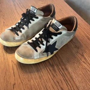 Golden goose skor - Säljer nu ett par sjukt feta Golden Goose dojjor i storlek 43. Tyvärr har jag inte box och dustbag därav priset. Som man ser på bild 4 har skorna en fläck på höger sko. Annars sjukt feta dojjor. Pris går att diskutera!