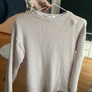 Beige stickad tröja - Mysig beige stickad tröja i bra skick. Perfekt för höst och vinter med sin varma och bekväma design. Tröjan har långa ärmar och en klassisk rund halsringning. Passar perfekt till både jeans och kjol för en avslappnad look.