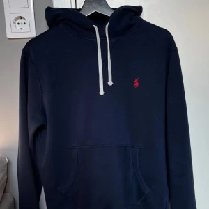 Ralph Lauren hoodie - Säljer en mörkblå Ralph Lauren hoodie då den blivit för liten. Tröjan är i mycket bra skick utan några defekter. 