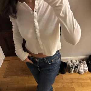 Vit croppad kofta från HM -  Vit croppad kofta från HM. Den har långa ärmar och knappar framtill. Storlek S, 100% bomull. Knappt använd🥰