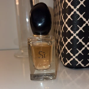 Si Parfym från Giorgio Armani - Säljer en elegant och tidlös Si parfym från Giorgio Armani. Flaskan är stilren med en svart kork och innehåller en ljuvlig doft av rosor, svarta vinbär och vanilj. Perfekt för både dag och kväll!🥰