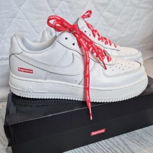 Nike Air Force 1 Supreme  - Sonen säljer sina Nike Air Force 1 Supreme skor i orginalkartong.  Köpta i Augusti, sparsamt använda mest stått på hyllan för att beskåda. 😄  Stl 41 (innermått ca 26,5cm)  Fint skick, inget trasigt men lite använda är de, så inte i nyskick.!  Medföljer även vita helt oanvända skosnören. Har fler bilder om någon önskar ✨️🤗 Pris kan diskuteras 👍🏻 