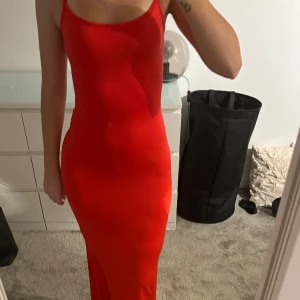 Röd långklänning med öppen rygg - Säljer en snygg röd långklänning med smala axelband och en elegant öppen rygg. Perfekt för festliga tillfällen! Klänningen har en tight passform som framhäver figuren. Perfekt nu inför julen❤️