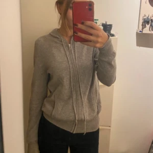 Grå hoodie från Soft Goat - Säljer min populära Kashmir kofta från soft goat. Använt sparsamt och finns inga riktigt tecken på slitage förutom ett litet hål på armbågen som är jätte lätt att åtgärda, jag har bara inte gjort det! Nypris 1900kr när jag köpte den. Skriv gärna för frågar mm! (: 