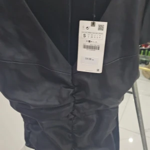 Svart klänning med v-ringning oanvänd och pris kan diskuteras - Elegant svart klänning med v-ringning och figurnära passform. Perfekt för en stilren look.