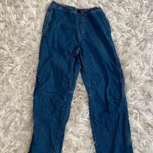 Blå jeansbyxor från H&M - Säljer ett par blå jeansbyxor från H&M i loose fit. De har en justerbar midja för extra komfort och en avslappnad stil. Perfekta för vardagsbruk och passar till det mesta. Byxorna är i bra skick och redo för en ny ägare!