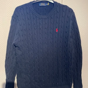 Mörkblå stickad tröja från Polo Ralph Lauren - Säljer en kabel stickad tröja från Raphl lauren i storlek M. Bra nu till vinter 