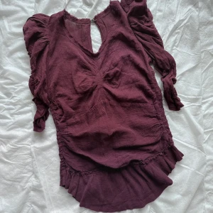Vinröd blus med volangdetaljer - Säljer en Isabel Marant vinröd blus med en öppning i ryggen. Den är tyvärr lite för liten för mig så väljer att sälja den vidare. Super bra skick