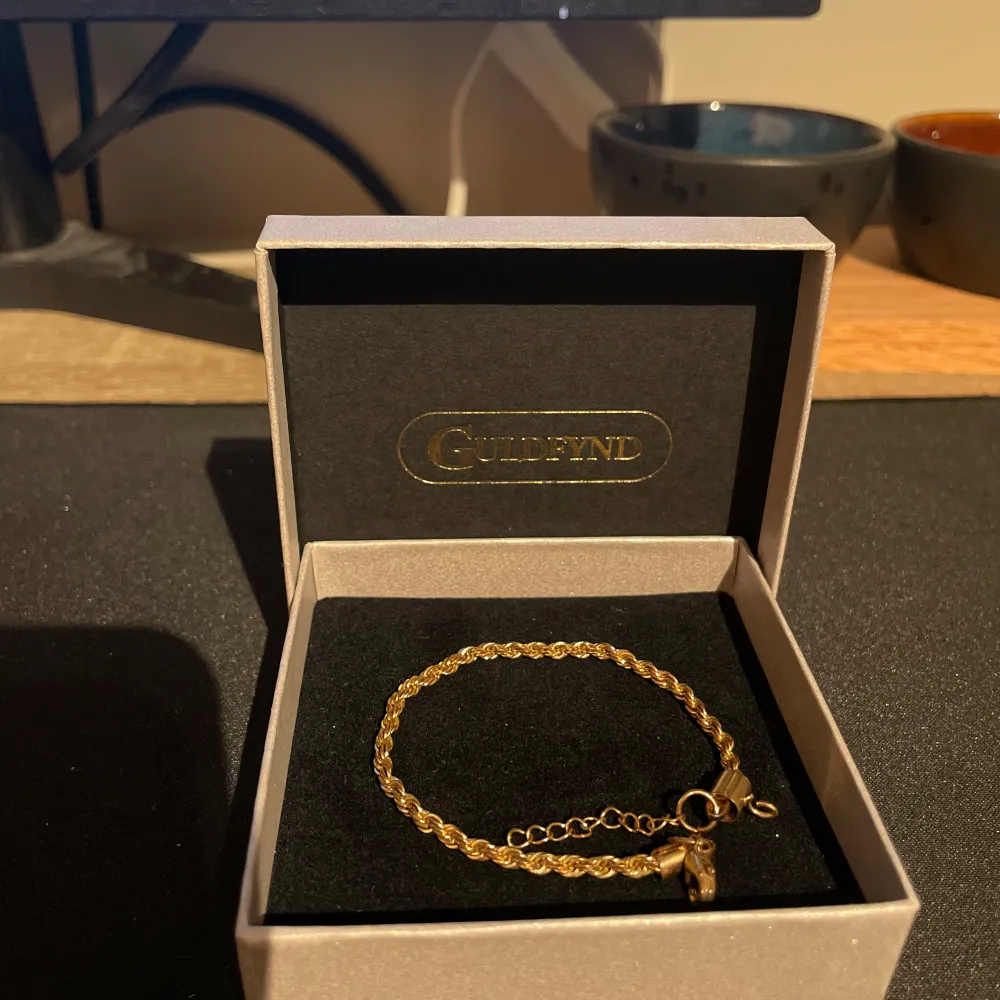 Säljer ett elegant guldfärgat armband från Guldfynd. Armbandet har en fin kedjedesign och justerbar längd med en säker låsning. Perfekt för både vardag och festliga tillfällen. Kommer i originalförpackning.. Asusteet.