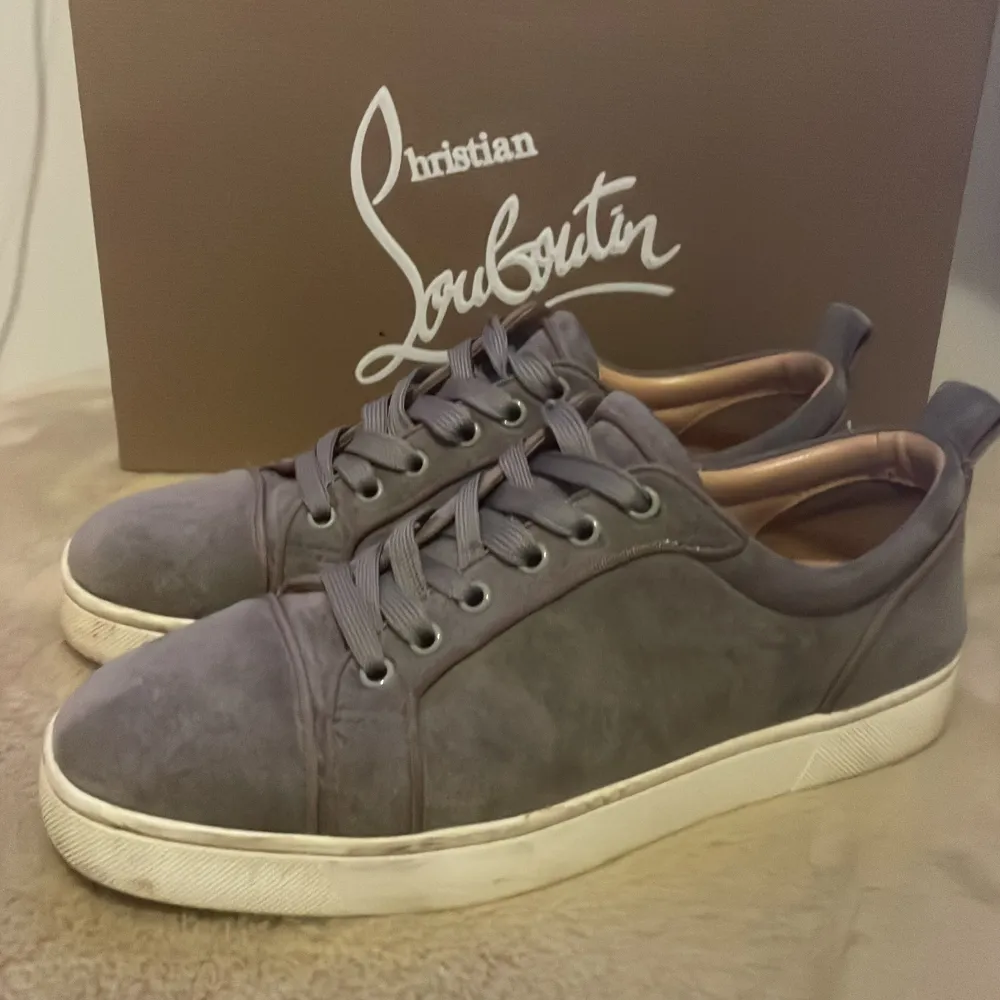 Snygga grå sneakers från Christian Louboutin i mocka med den ikoniska röda sulan. Skorna har snörning och en stilren design. Skorna är i storlek 39. Kartong och påse ingår, tyvärr har jag ej kvittot kvar. . Skor.