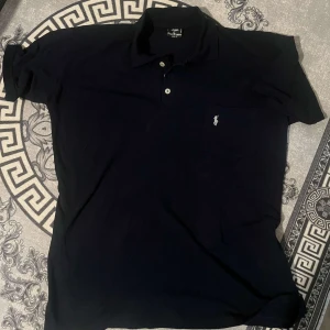 Svart ralph lauren piké - Tja säljer min piké då jag inte använder den Den är i bra skick och använt den bara några gånger Går att byta mot nåt annat!!