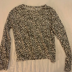 Leopardmönstrad långärmad tröja - Säljer en supercool leopardmönstrad tröja med långa ärmar. Perfekt för att ge din outfit lite extra edge! Tröjan är i bra skick och passar perfekt till både vardag och fest. 🐆✨
