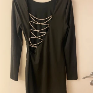 Svart klänning med snörning - Snygg svart klänning med öppen rygg