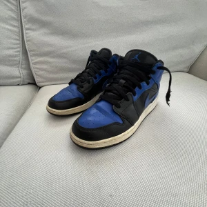 Nike Air Jordan 1 mid Royal Blue storlek 40 - Säljer ett par Nike Air Jordan 1 mid i storlek 40, 25 cm. Små i storlek mer som 39. Skon är lagad hos skomakare i bakkappan på båda skorna men i övrigt i fint använt skick, se bilder.