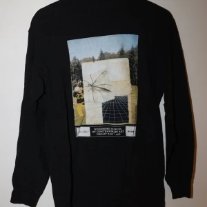 Svart långärmad tröja med tryck  - Säljer en svart långärmad tröja med ett coolt tryck på framsidan. Storleken är antingen S för kille eller M för tjejer skulle jag säga. 