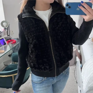 Svart cardigan med päls - Säljer en supermysig svart jacka med pälsdetaljer på framsidan. Den har långa ärmar i stickat material och en dragkedja framtill. Perfekt för höst och vinter när du vill hålla dig varm och stilren. Passar till både vardag och fest! Cardigan ribbad o päls, sista bilden är egen
